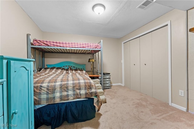 bedroom featuring a closet, a textured ceiling, and carpet flooring