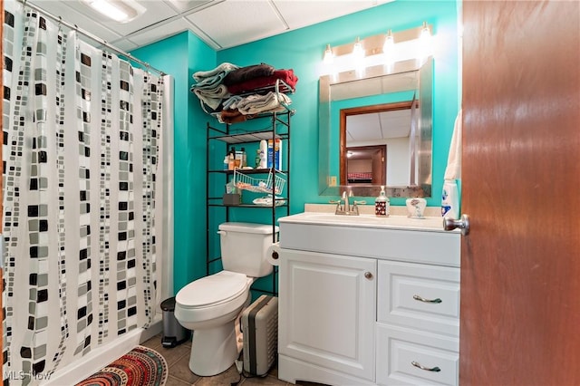 bathroom featuring a paneled ceiling, tile patterned floors, toilet, and walk in shower