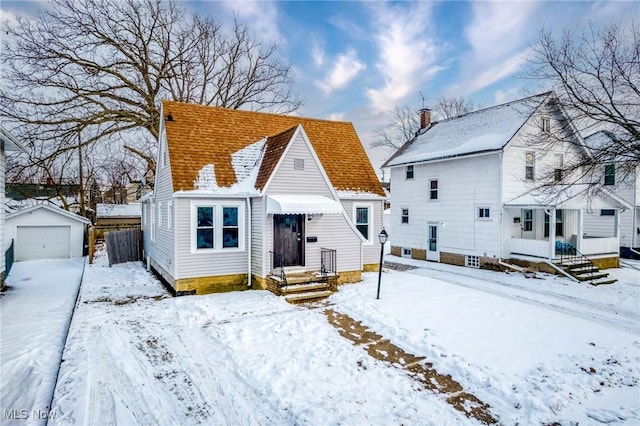 view of front of house with a garage and an outbuilding