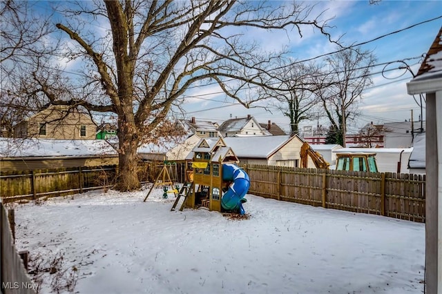 yard layered in snow featuring a playground