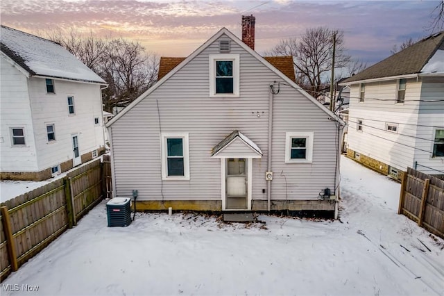 snow covered rear of property with central AC unit