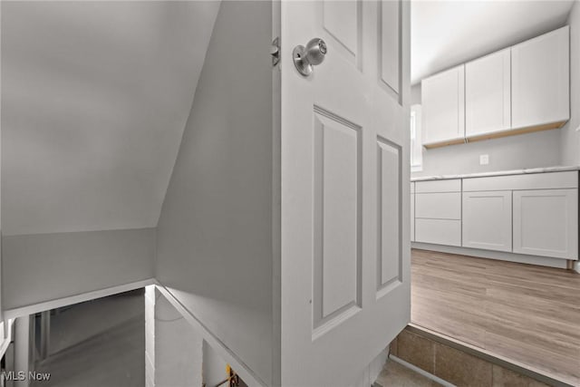 staircase featuring lofted ceiling