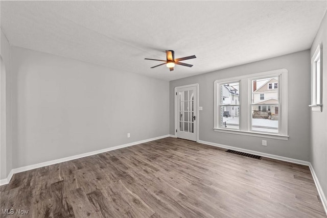 empty room featuring hardwood / wood-style flooring, a textured ceiling, and ceiling fan