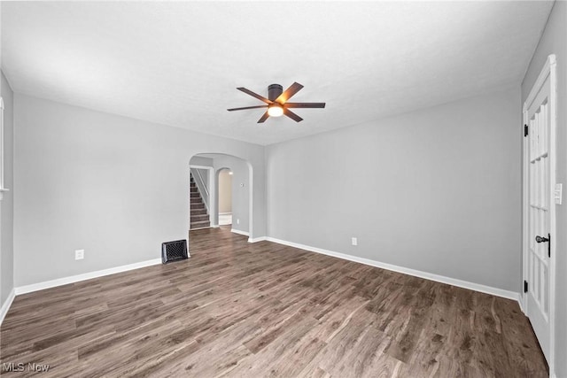 empty room with dark hardwood / wood-style flooring and ceiling fan