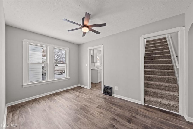 interior space with dark hardwood / wood-style flooring, sink, a textured ceiling, and ceiling fan