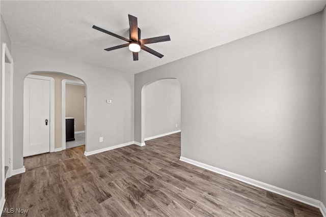 unfurnished room featuring dark hardwood / wood-style flooring and ceiling fan