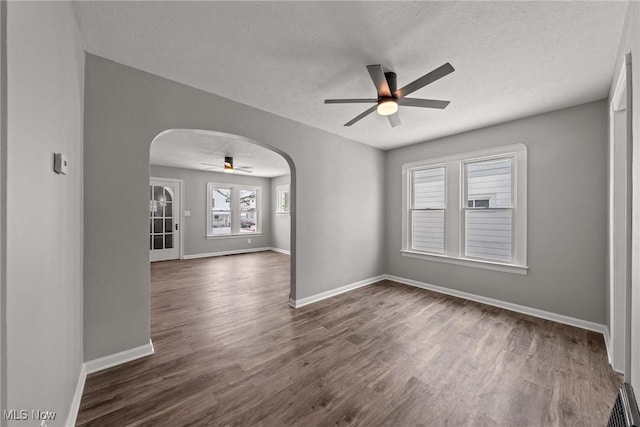 spare room with ceiling fan, dark wood-type flooring, and a textured ceiling