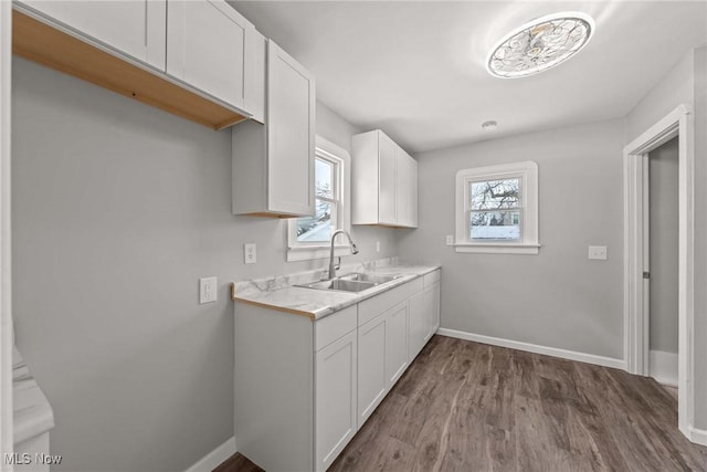 kitchen featuring white cabinetry, sink, and hardwood / wood-style floors