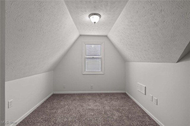 bonus room with lofted ceiling and carpet floors