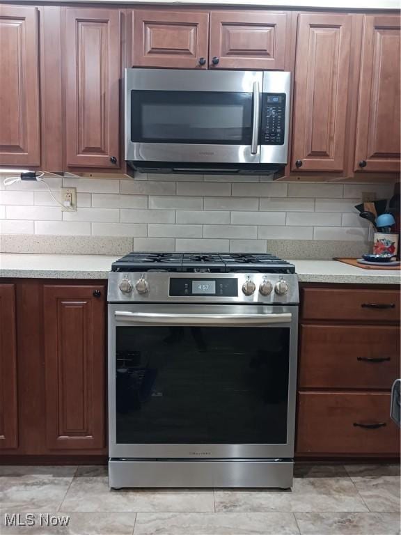 kitchen with appliances with stainless steel finishes and decorative backsplash