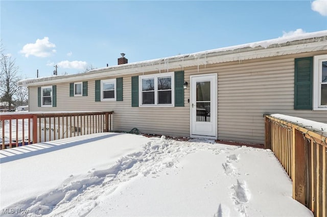 view of snow covered back of property