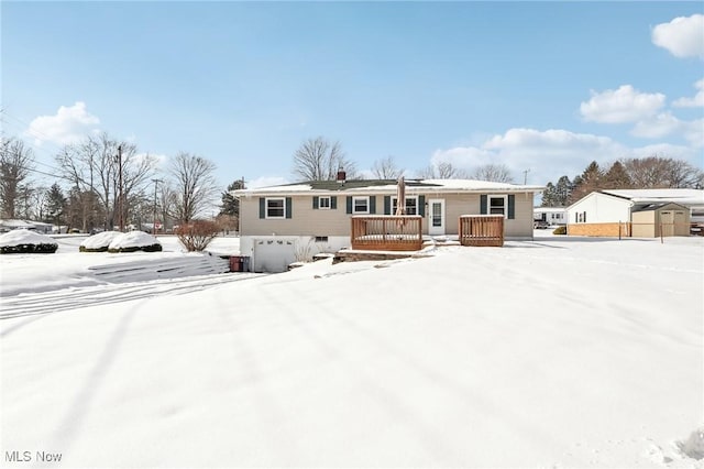 snow covered back of property with a garage