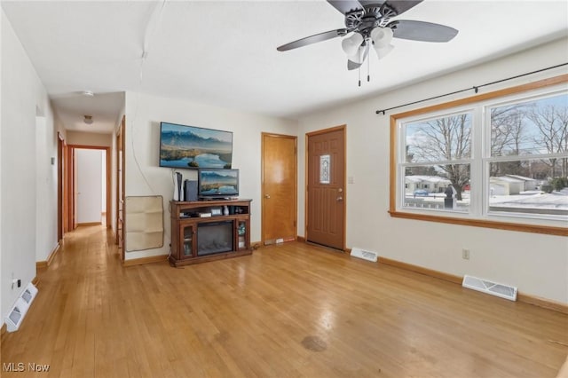 living room featuring light hardwood / wood-style floors and ceiling fan