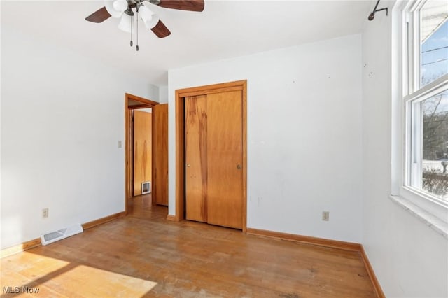 unfurnished room featuring ceiling fan, light hardwood / wood-style flooring, and a healthy amount of sunlight