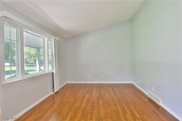 unfurnished room with hardwood / wood-style flooring and plenty of natural light