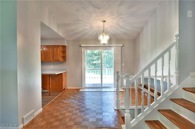 doorway to outside featuring an inviting chandelier and light parquet floors