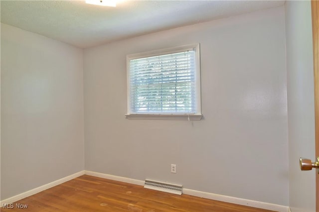 unfurnished room with hardwood / wood-style floors