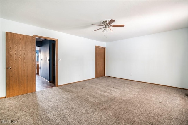 carpeted spare room featuring ceiling fan