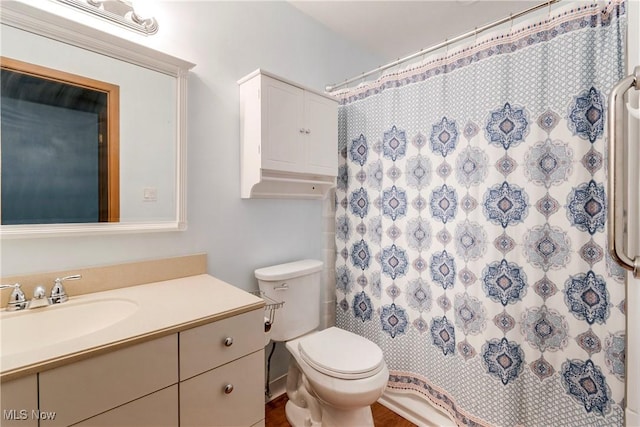 bathroom featuring vanity, walk in shower, and toilet