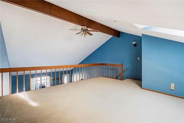 bonus room with ceiling fan, carpet, and vaulted ceiling with beams