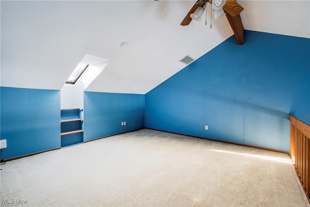 additional living space with light carpet, lofted ceiling with skylight, and ceiling fan