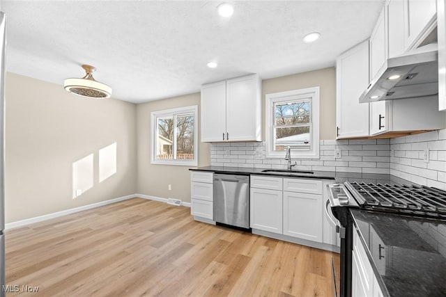 kitchen featuring backsplash, appliances with stainless steel finishes, sink, and white cabinets