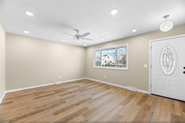 entrance foyer with ceiling fan, light hardwood / wood-style flooring, and a textured ceiling