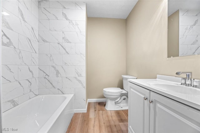 full bathroom with vanity, toilet, tiled shower / bath combo, and hardwood / wood-style floors