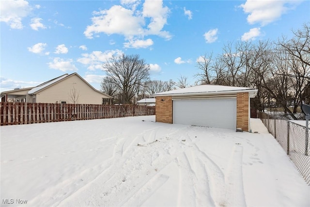 yard covered in snow with a garage and an outdoor structure