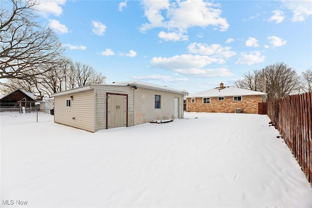 view of snow covered back of property