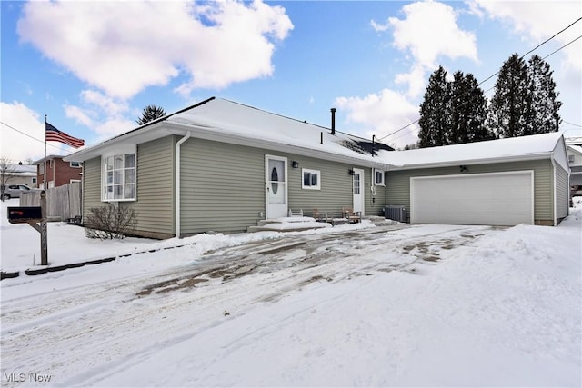 single story home featuring a garage and central AC unit