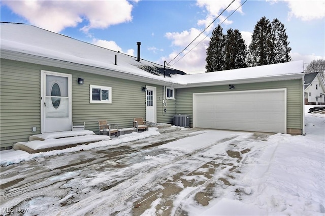 single story home featuring a garage and central air condition unit