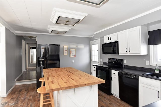 kitchen featuring dark wood-type flooring, a breakfast bar area, white cabinetry, ornamental molding, and black appliances