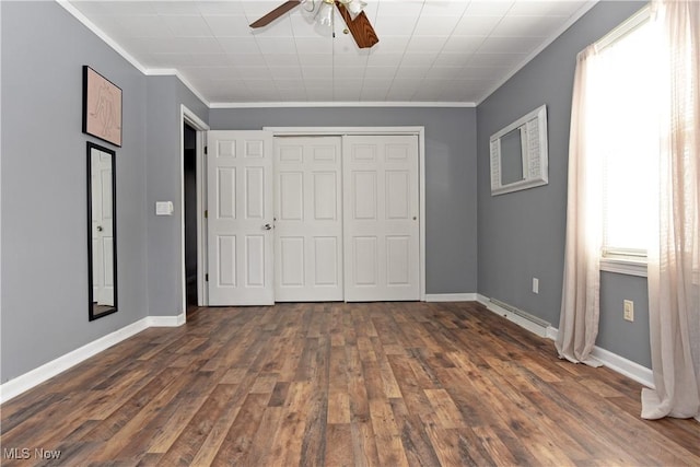 unfurnished bedroom featuring a closet, crown molding, dark hardwood / wood-style floors, and ceiling fan