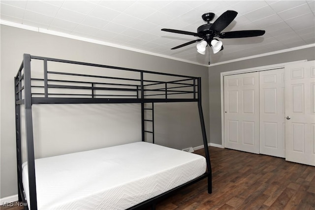 bedroom featuring crown molding, dark hardwood / wood-style floors, ceiling fan, and a closet