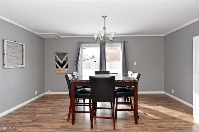 dining area featuring crown molding, dark hardwood / wood-style floors, and an inviting chandelier