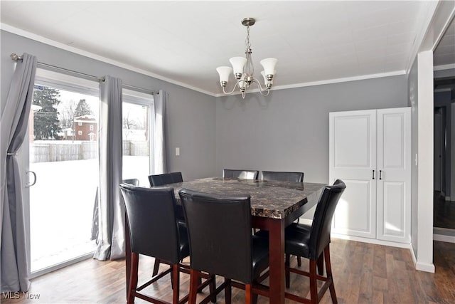 dining room with crown molding, dark hardwood / wood-style floors, and an inviting chandelier