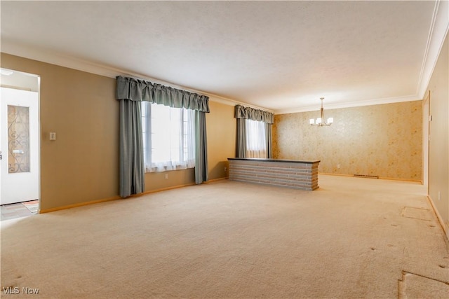 unfurnished living room with an inviting chandelier, crown molding, and carpet flooring