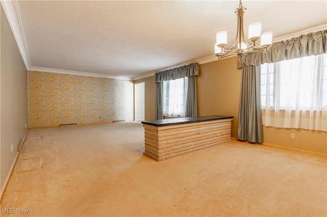 spare room with ornamental molding, carpet, and a notable chandelier