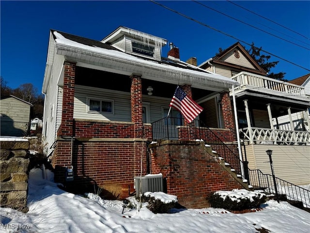 bungalow-style house featuring cooling unit, a balcony, and covered porch