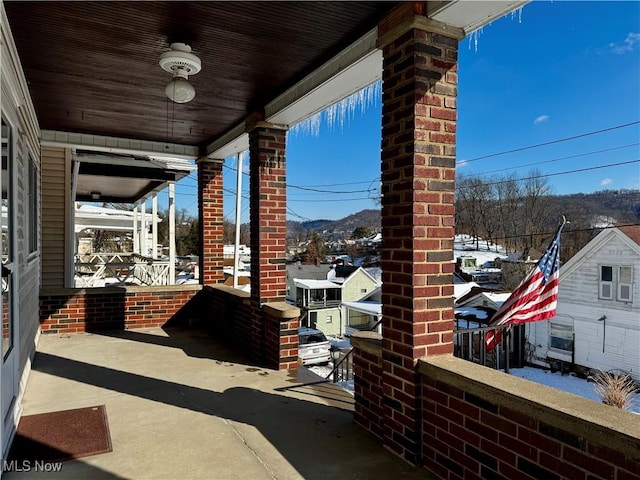 view of patio with a porch, a mountain view, and ceiling fan