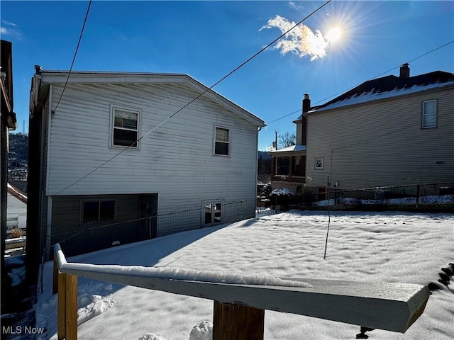 view of snow covered rear of property