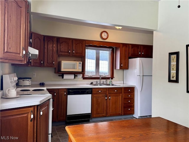 kitchen featuring white appliances, dark tile patterned floors, sink, and exhaust hood