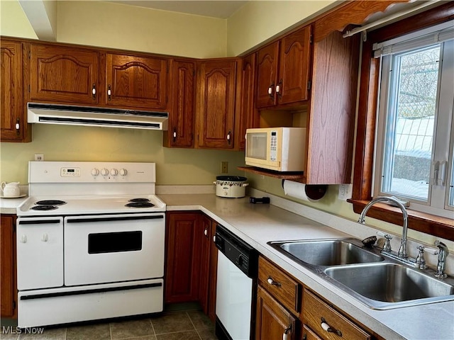 kitchen featuring dark tile patterned floors, sink, and white appliances