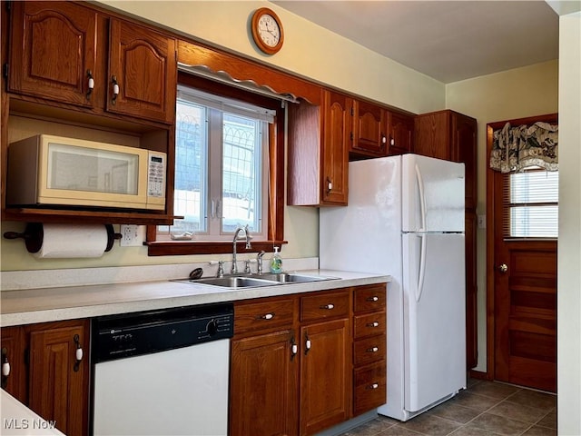 kitchen featuring white appliances, sink, and dark tile patterned floors