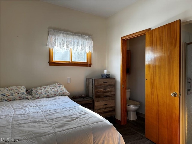 bedroom featuring dark hardwood / wood-style flooring and ensuite bath