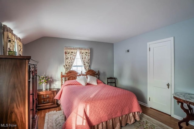 bedroom featuring vaulted ceiling and hardwood / wood-style floors