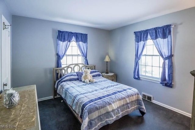 carpeted bedroom featuring multiple windows