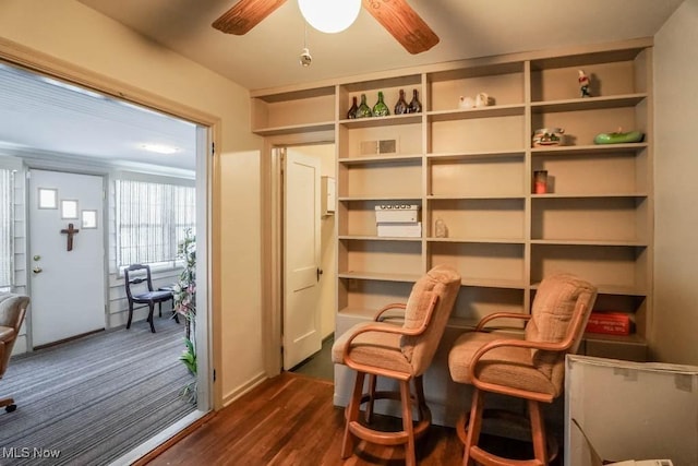 living area featuring dark wood-type flooring and ceiling fan