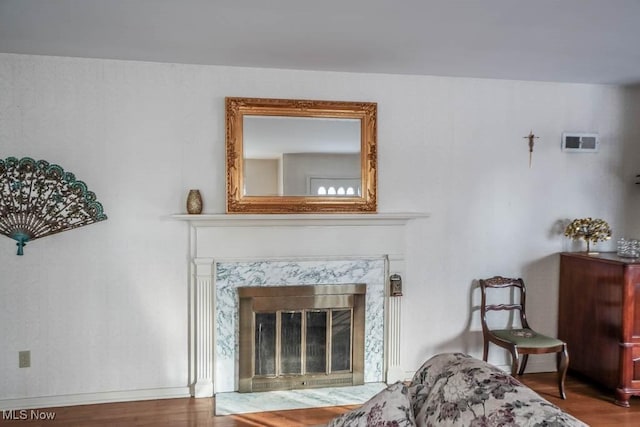 living area featuring wood-type flooring and a fireplace